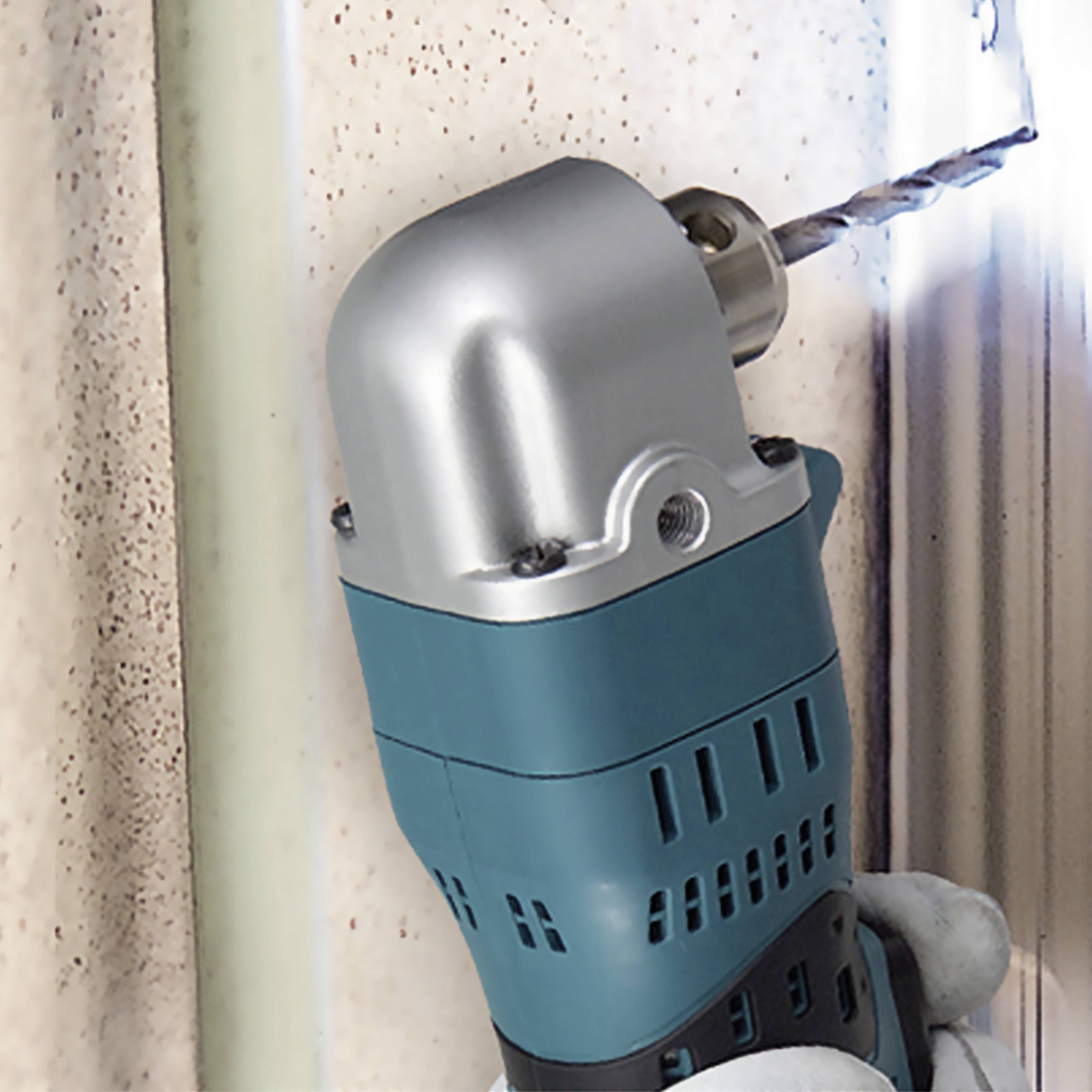 A hand drill is drilling a hole in a blue wall using a metal drill bit. Dust is generated as the drill operates.