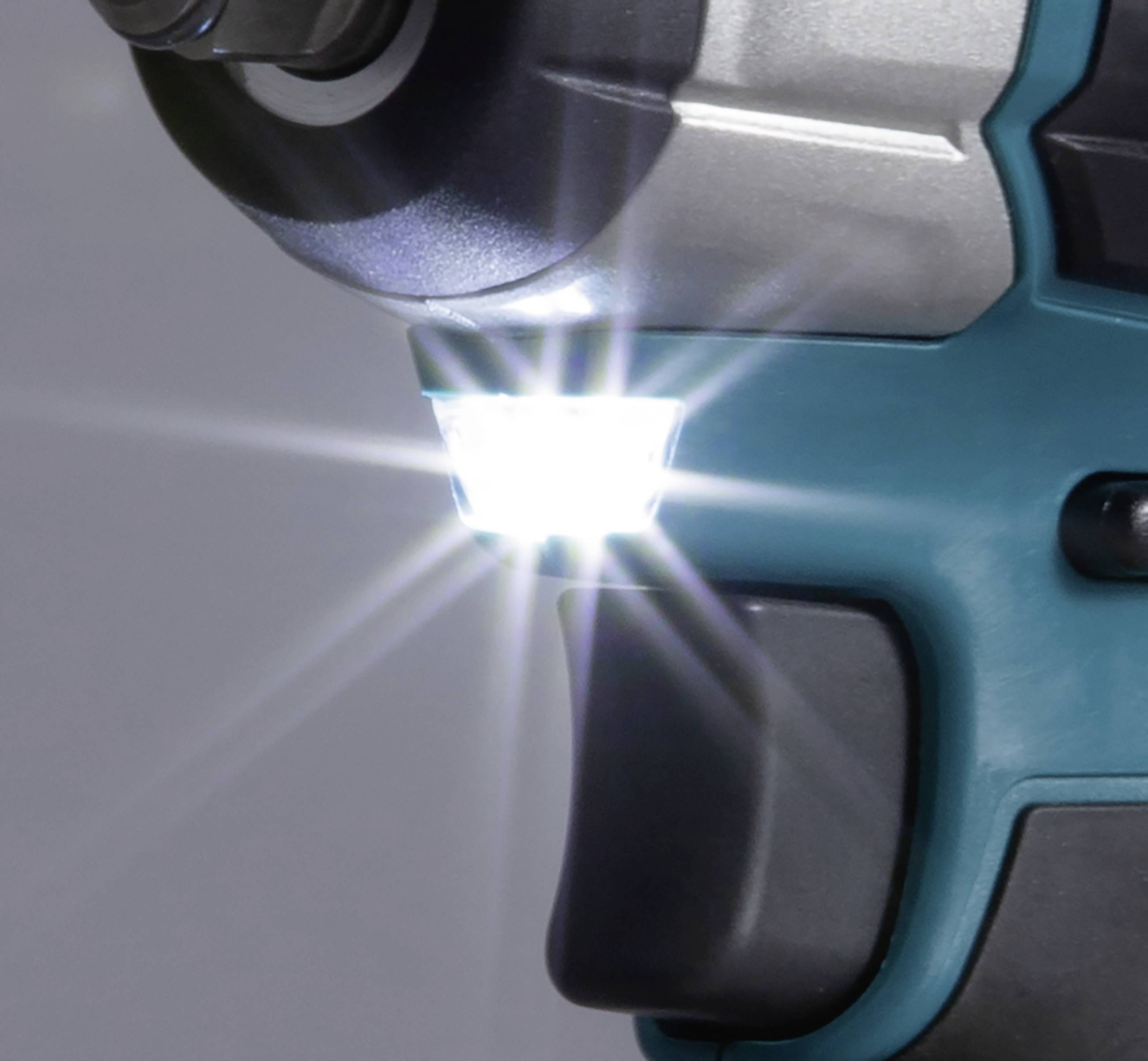 A cordless drill with an illuminating LED light against a blurred background.