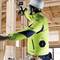 A worker in protective clothing and hard hat is using an electric drill to secure wooden construction within a building.