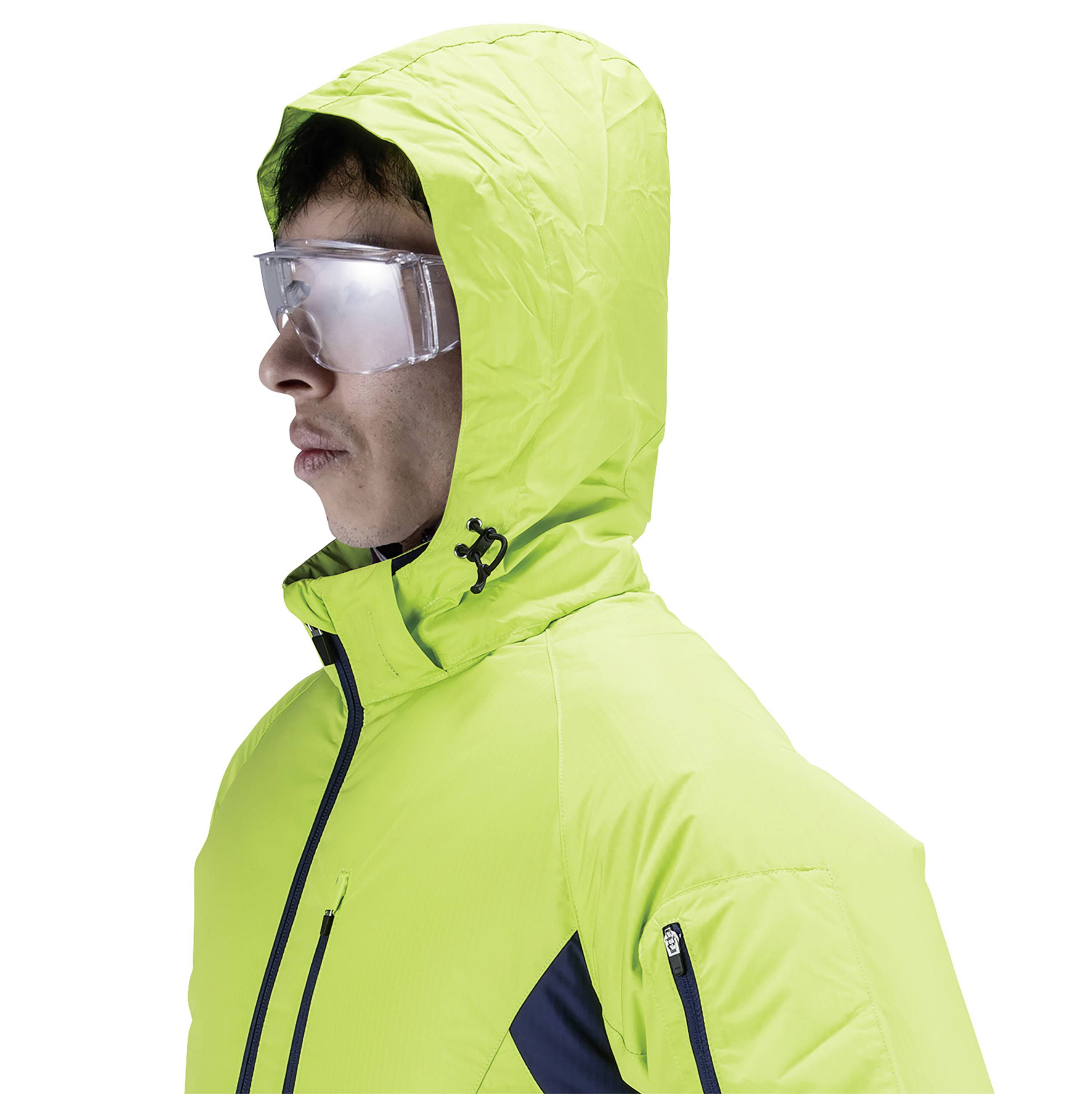 A person is wearing a bright yellow winter jacket with a hood and reflective safety glasses. They are looking to the right.