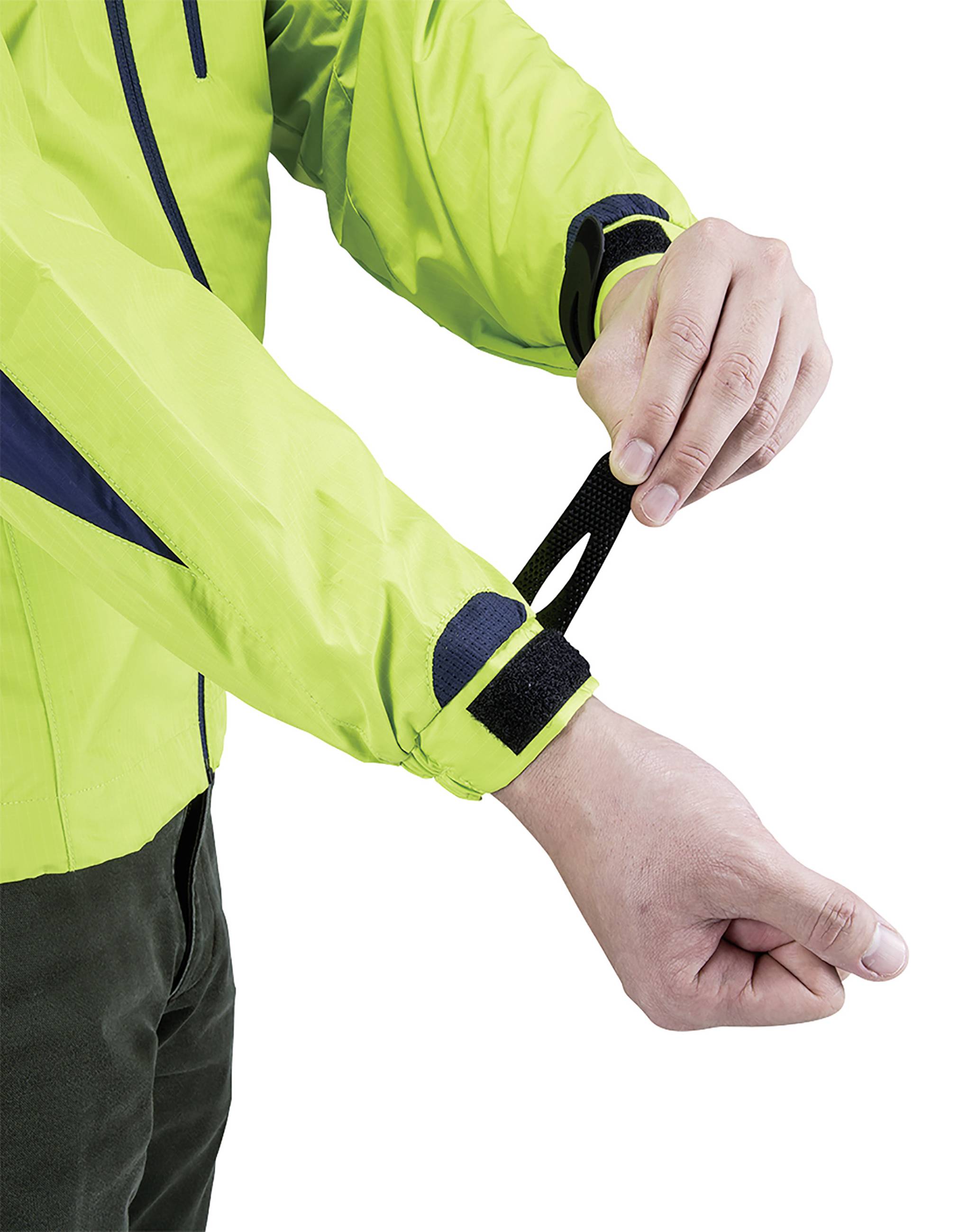 A person fastens the hook and loop fastener on a brightly green jacket sleeve.