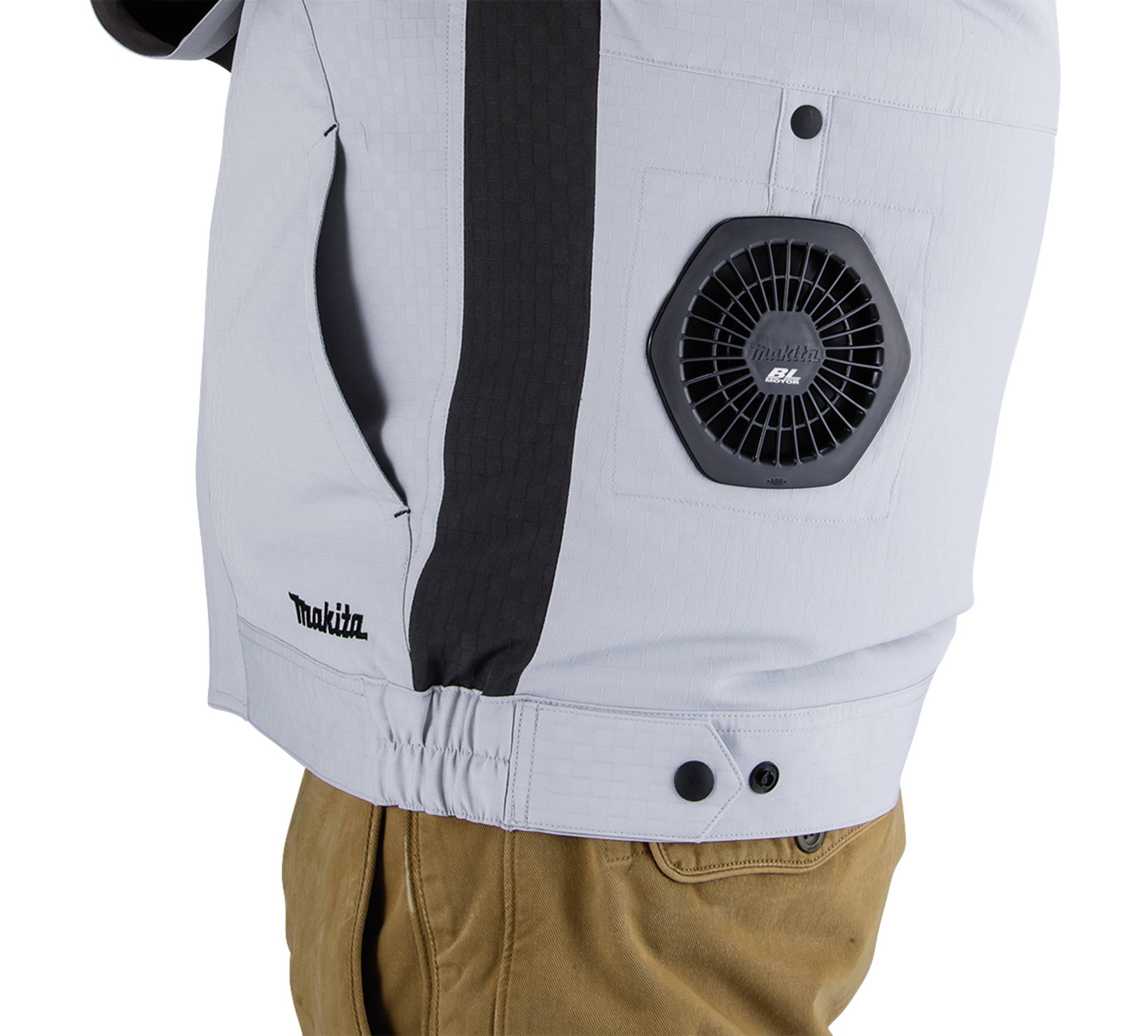 A grey garment with an integrated fan on the side, worn by a person. The fan bears the logo of a brand.