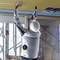 A person in work attire and a hard hat is installing a ceiling using an electric tool on a construction site.