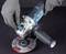 'A person wearing grey gloves is installing a grinding disc onto an angle grinder.'
