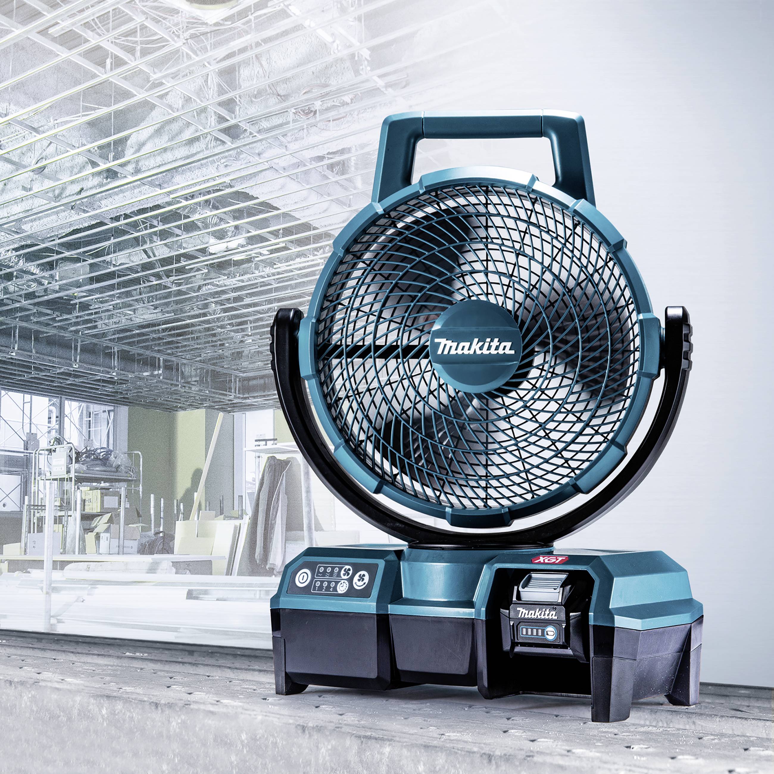 A blue, battery-powered desk fan with the brand name on the front, positioned on a table in front of a modern office building.