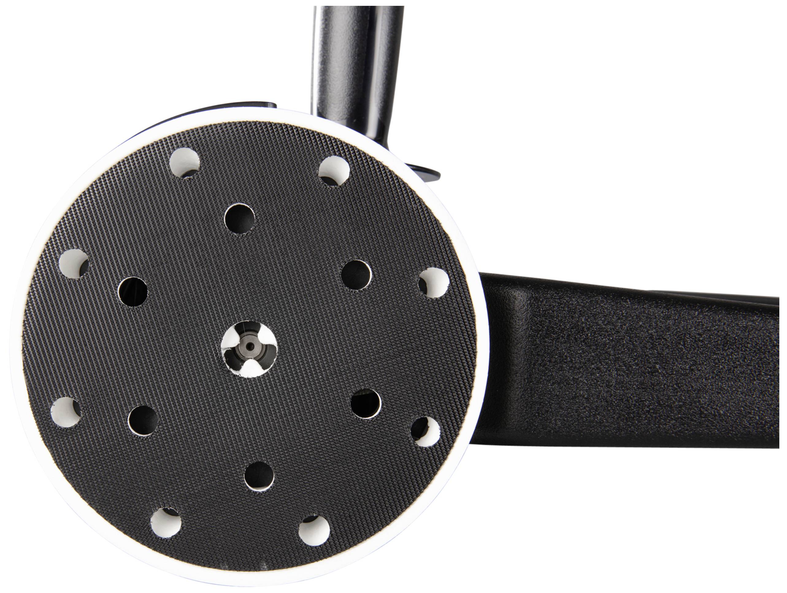 A close-up of a round electric grinding head with multiple holes on a workbench.