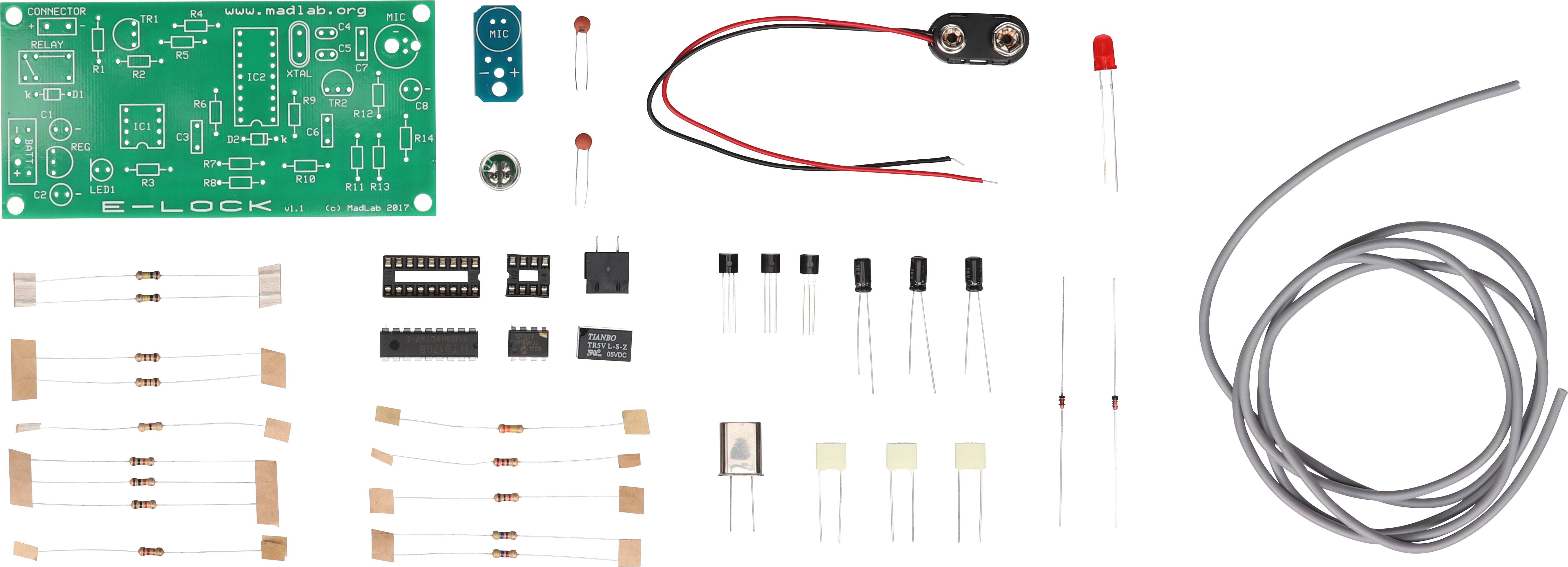 Electronic kit with printed circuit board, resistors, transistors, LED, cables, and other components for assembly and soldering.