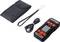 A digital battery testing device with cable, carrying loop and case. The device has a screen and control buttons.