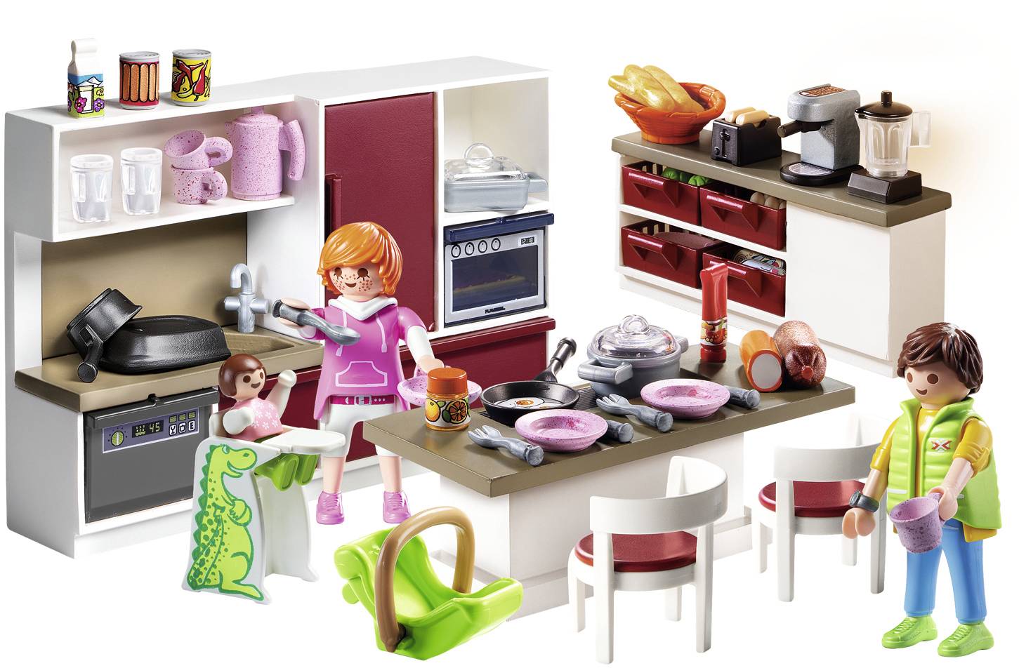 Toy kitchen with dolls. Two figures cooking at a cooker; crockery and cutlery are spread out on a table.