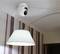 A ceiling-mounted security camera looking into a room with striped wallpaper and a white pendant light.