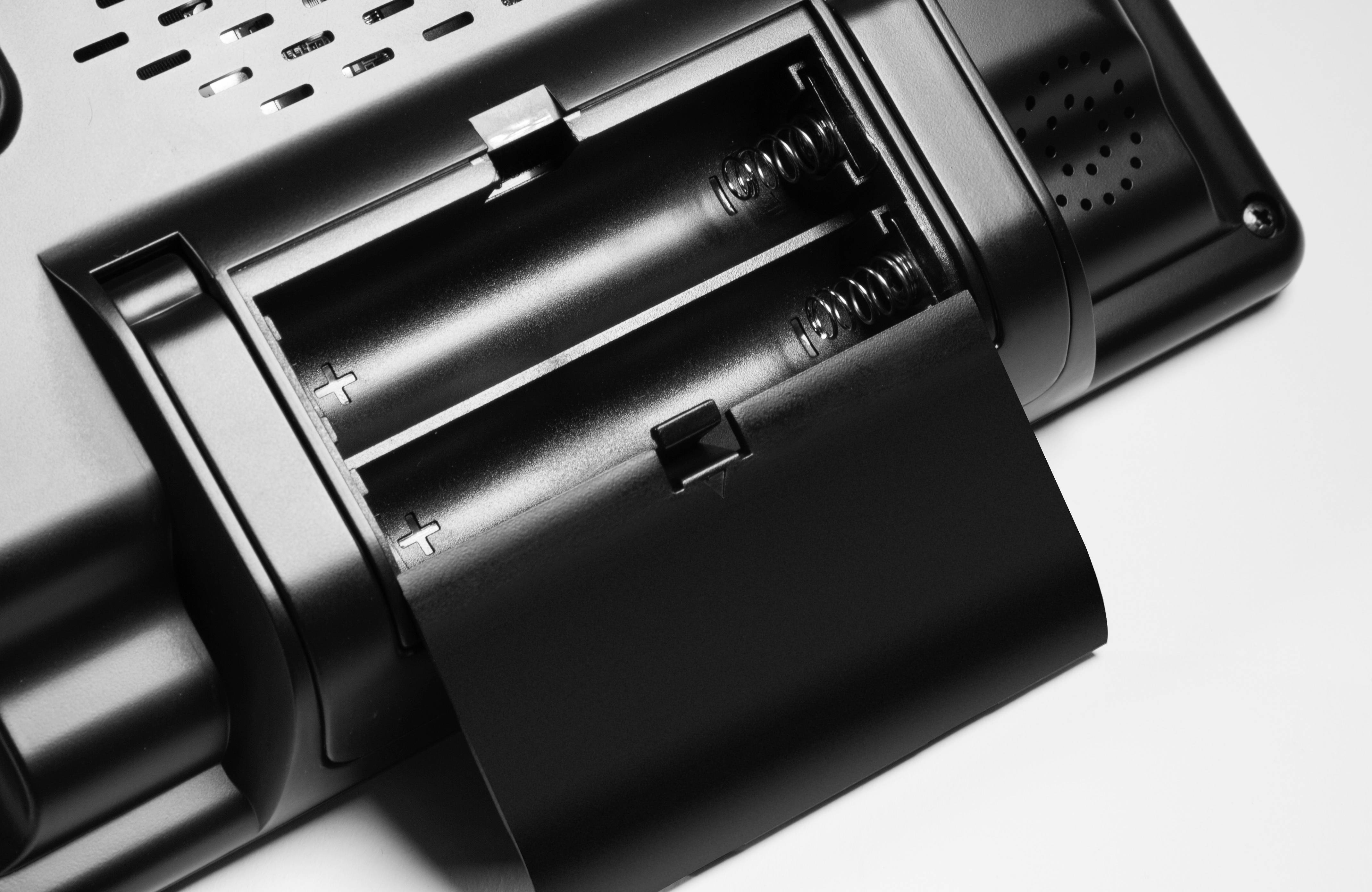 Two AA batteries in an open battery compartment of an electronic device. The compartment shows positive and negative poles.