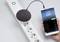 An intelligent power strip connects a speaker and a smartphone that is playing music.