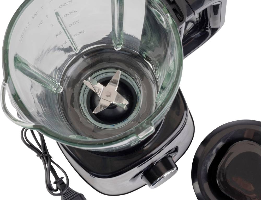A transparent blender with a glass container and visible blades. The lid is placed beside it, and the power cable is visible.