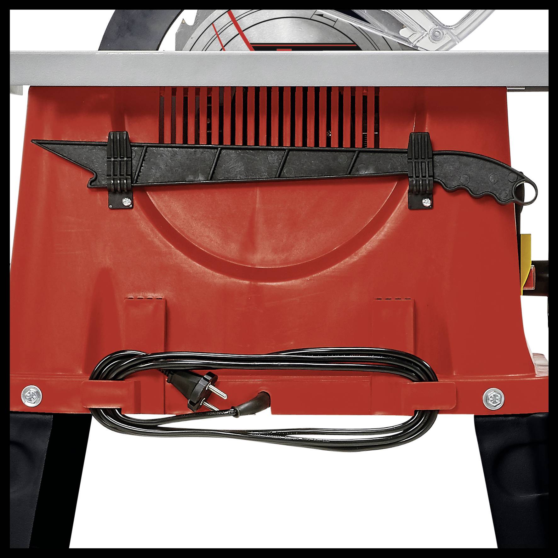 Red table saw with a folded black cable holder at the front. A spare saw blade is attached to the side.