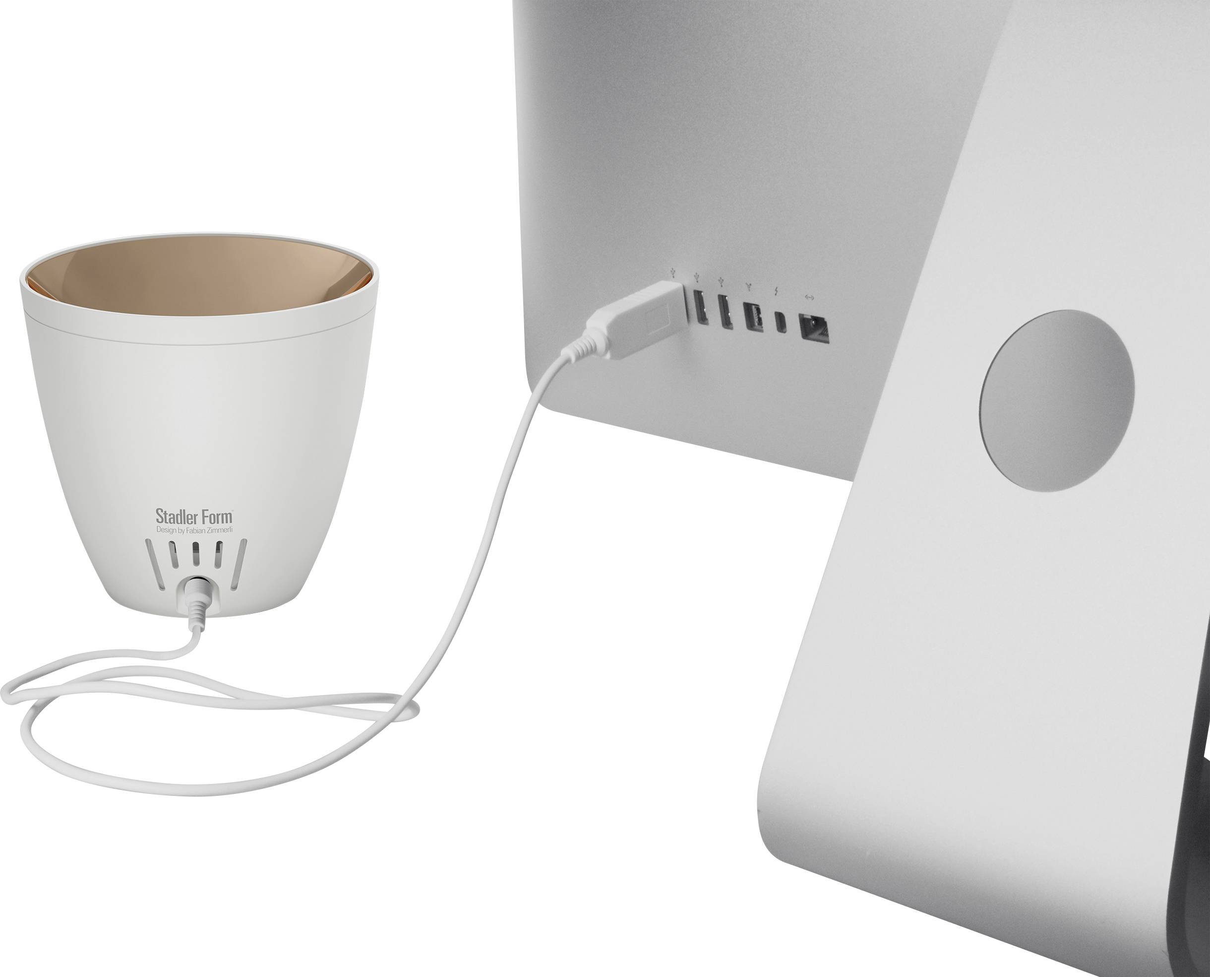 White desk humidifier bowl from Stadler Form placed next to a computer, connected via a USB cable.