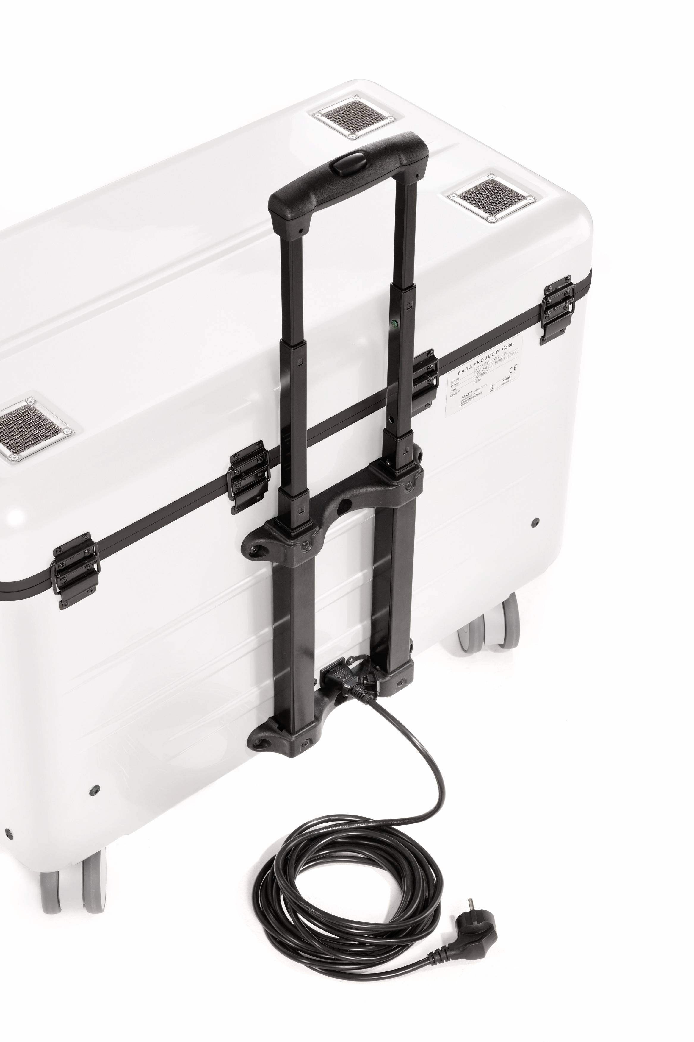 A white suitcase with an extendable handle on wheels. An electrical cable is connected to the suitcase.