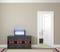 A modernly furnished room with an open door leading to a bedroom. A glowing UV lamp stands on the chest of drawers.