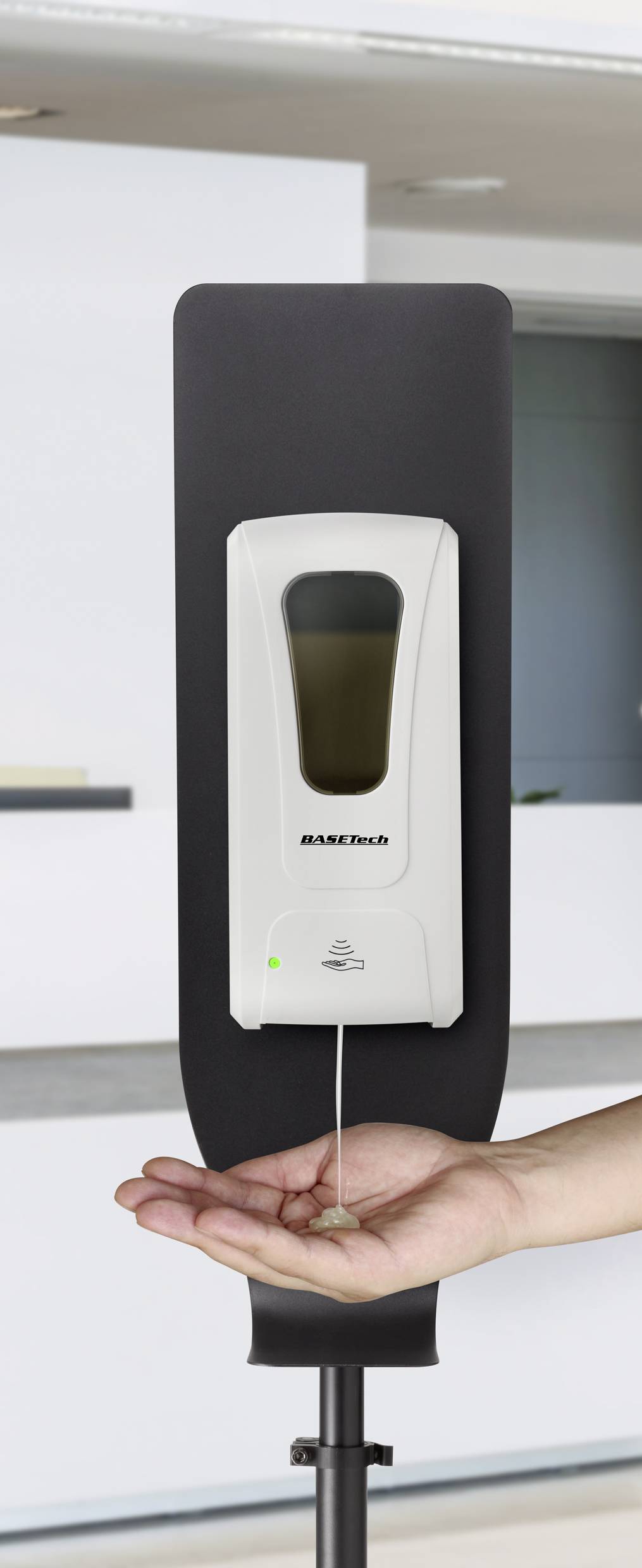 A touchless hand sanitiser dispenser with a hand receiving the sanitiser underneath.