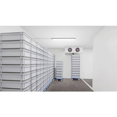 A storage room with stacks of large, gray plastic containers on movable carts, a cooling unit on the wall, and a bright overhead light.