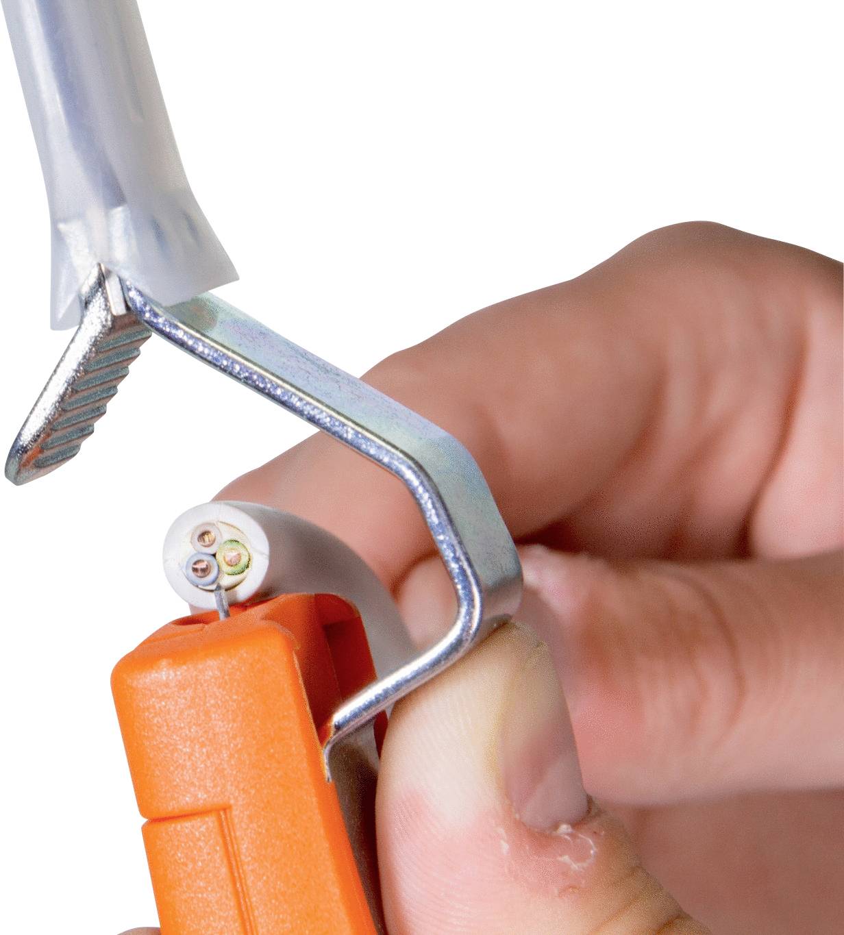 A hand is holding a cable tool that is securing a cable in a clamp.