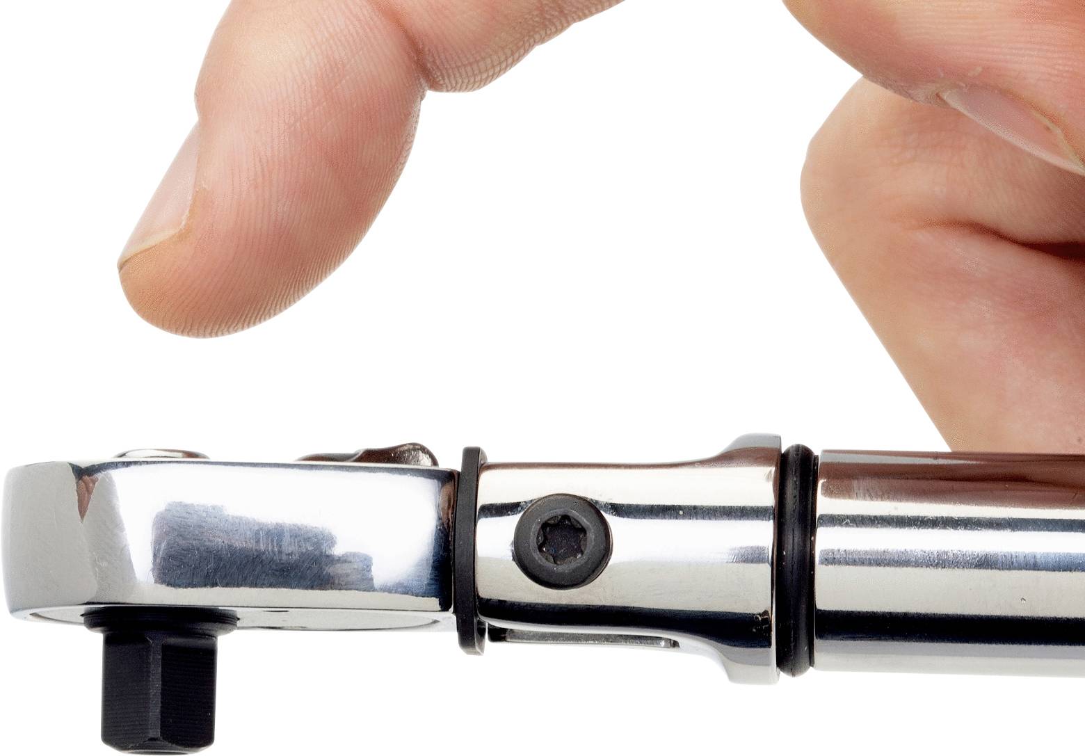 'Close-up of a hand holding a chrome-plated torque wrench against a black screw head. Precision tool application.'