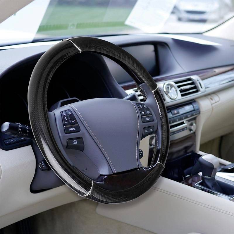 Steering wheel of a car with a brown-black covering, surrounded by the interior of a modern vehicle.