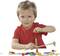 A child in a red shirt is playing intently with a wooden construction set, using a screwdriver to assemble parts.