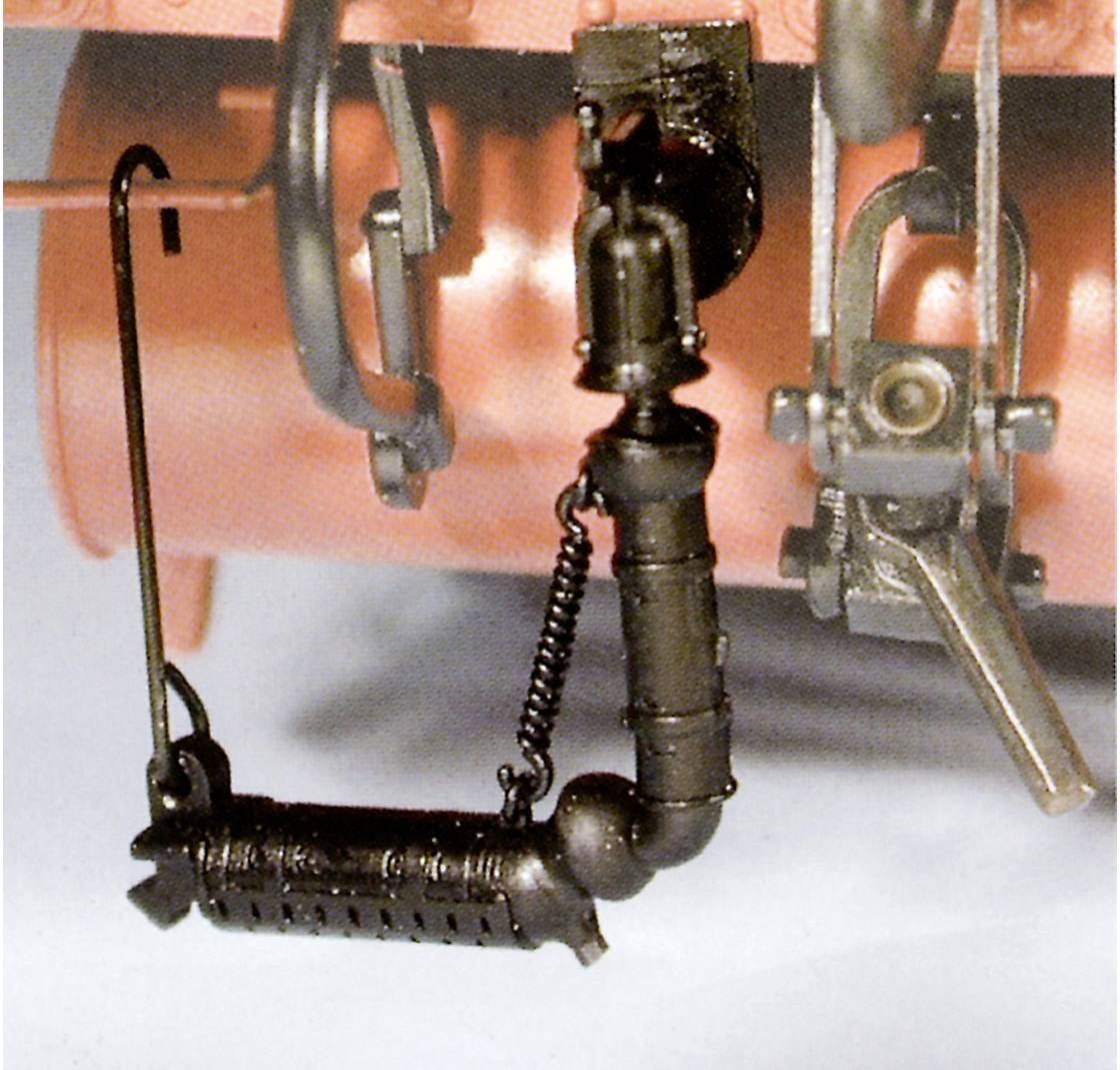 Close-up of a mechanical component on a vehicle, consisting of metal and featuring springs and hoses.