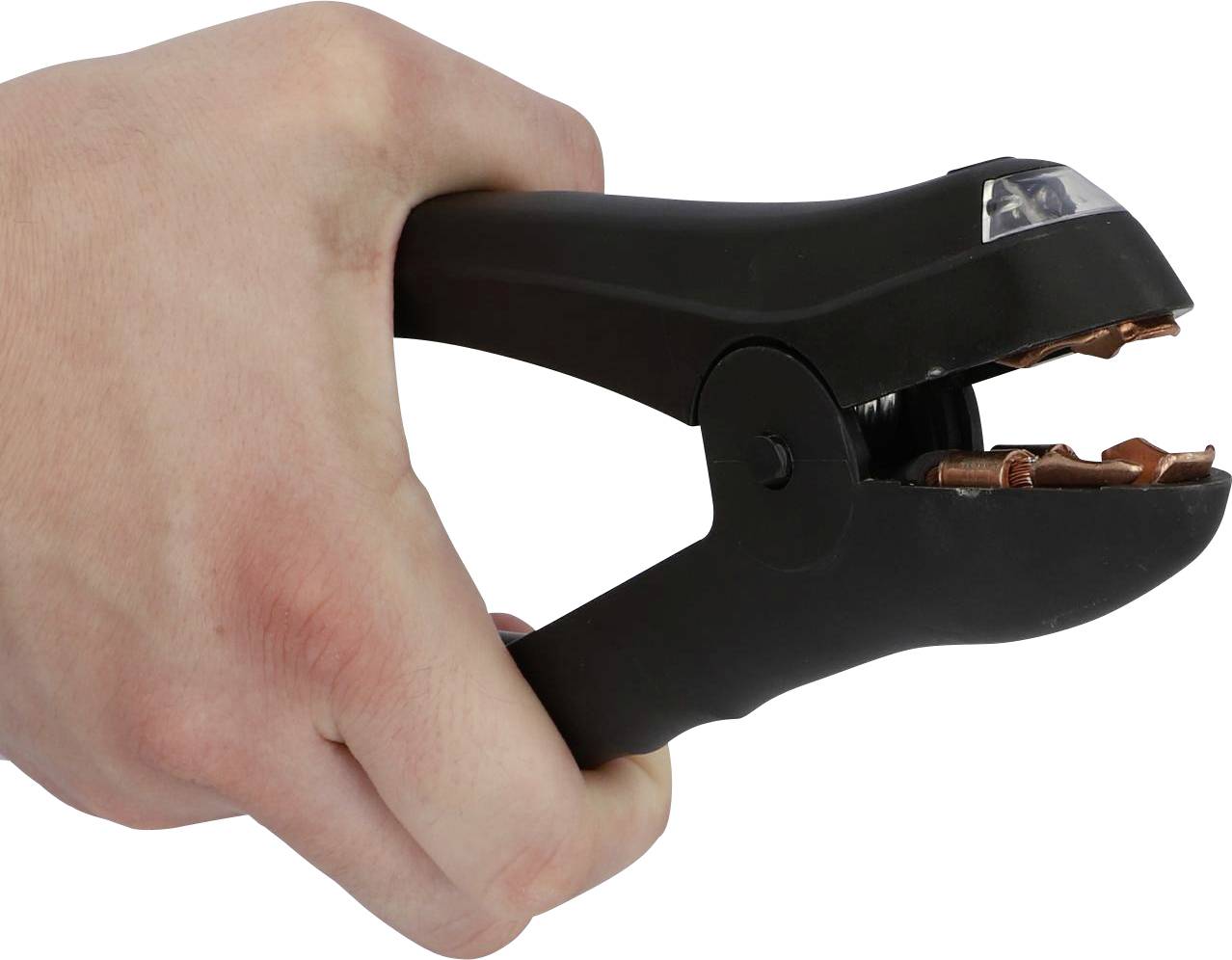 A hand is holding a black clamp that is making contact with a copper wire.