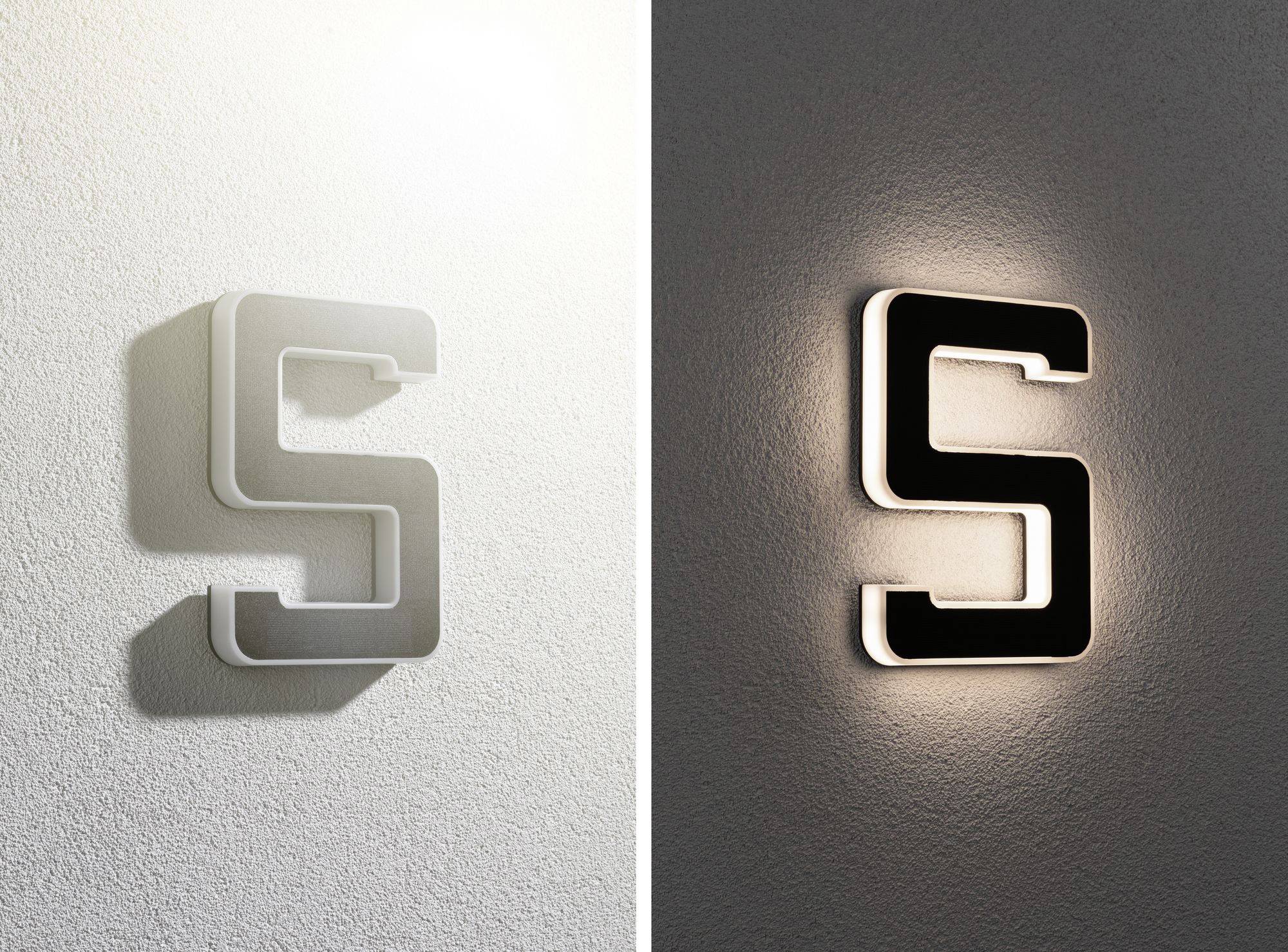 The letter 'S' is mounted on a wall, on the left in white with a shadow, on the right in black with a backlit glow.