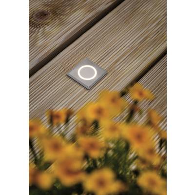 A luminous, square LED recessed light in a wooden decking, with yellow flowers blurred in the foreground.
