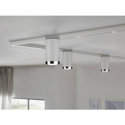 Three cylindrical ceiling lights mounted evenly along a track illuminate the room subtly in a modern space.