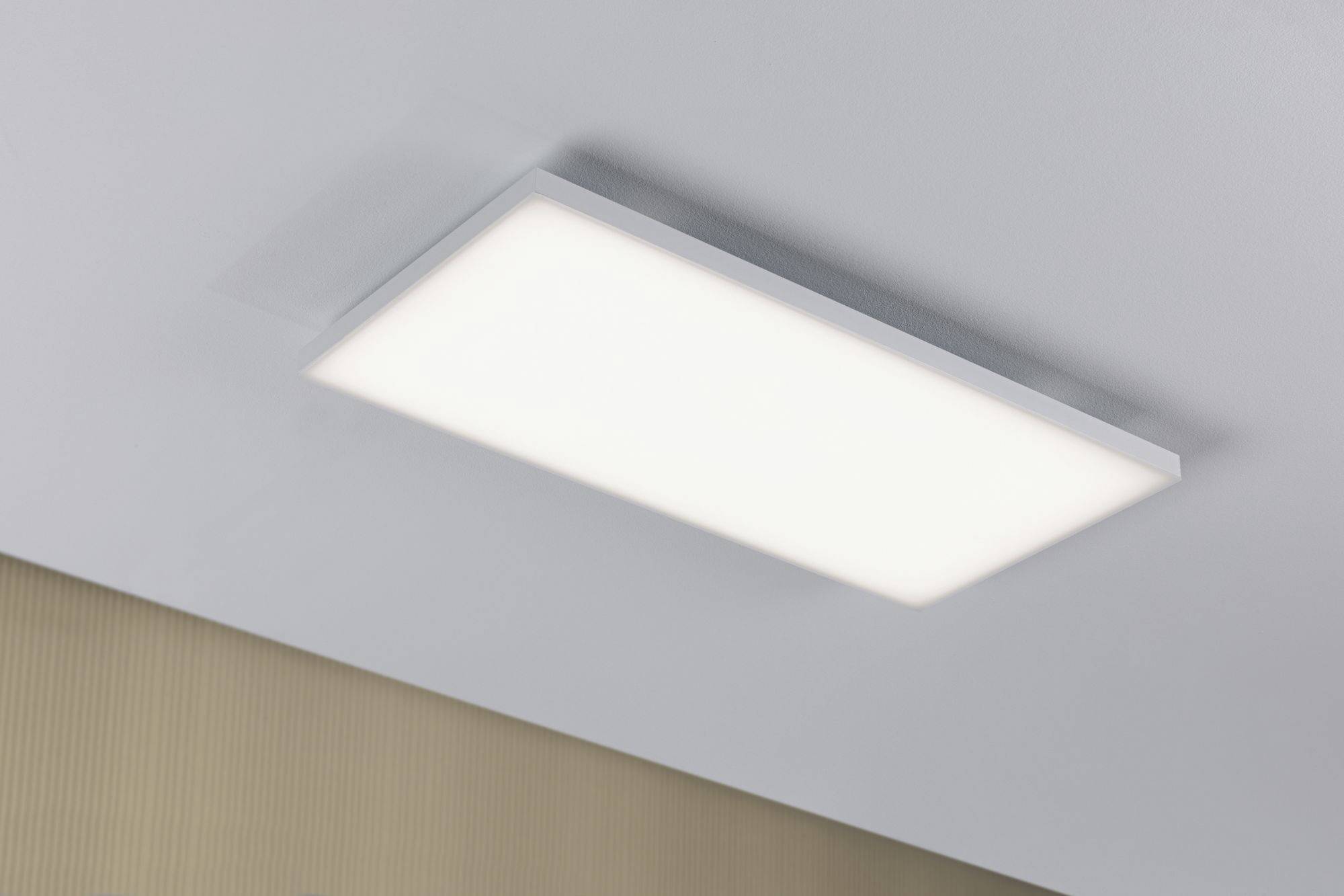 Rectangular ceiling light with uniform white illumination against a textured wall surface.