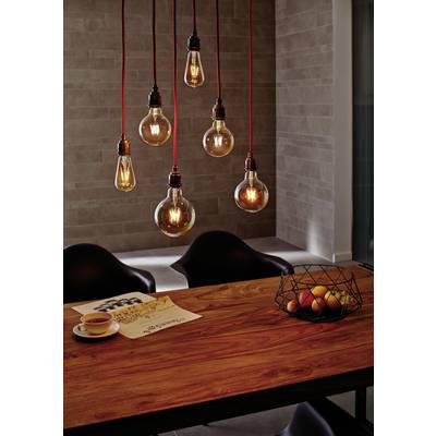 Six hanging light bulbs above a wooden table with a newspaper, teacup, and fruit basket. Modern, warm interior design.
