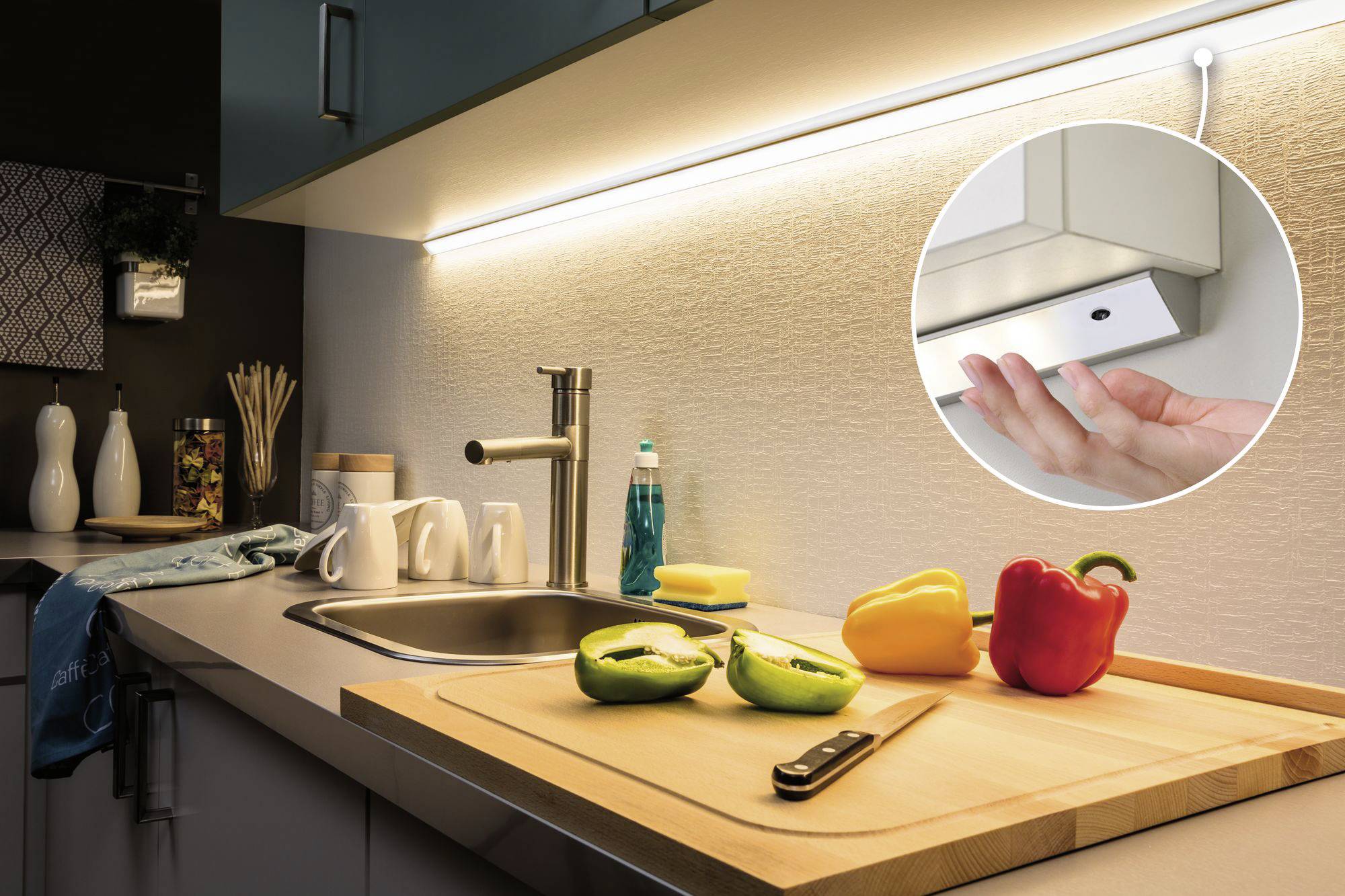 Modern kitchen with sliced pepper on a wooden chopping board. Under-cabinet lighting beneath the cupboard, close-up shows hand switching on the light.