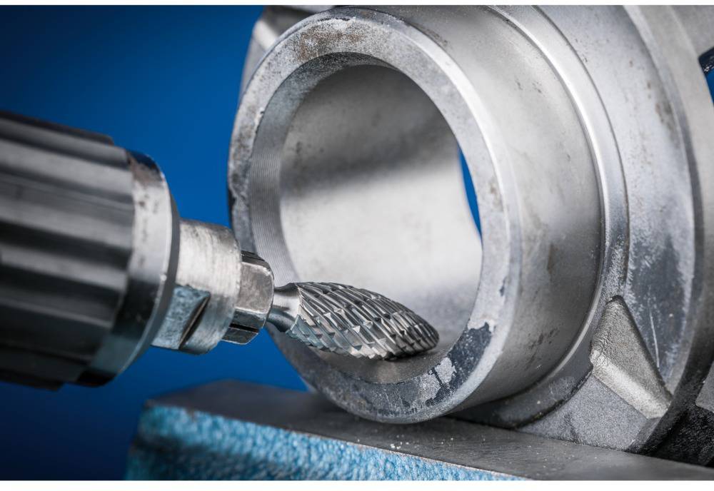 Close-up of a rotating milling cutter grinding metal from a ring-shaped surface. Focus on precision and craftsmanship.