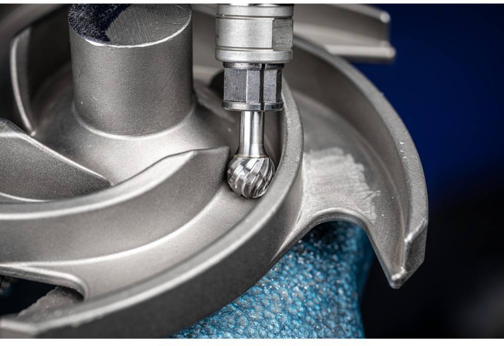 A metal milling machine precisely machines a rotating turbine wheel. Strong focus on the milling movement and the metal workpiece.