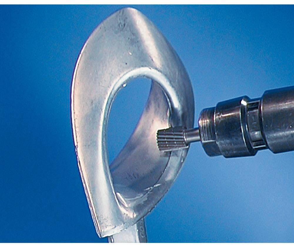 A tool is machining the inner surface of a metal piece against a blue background.