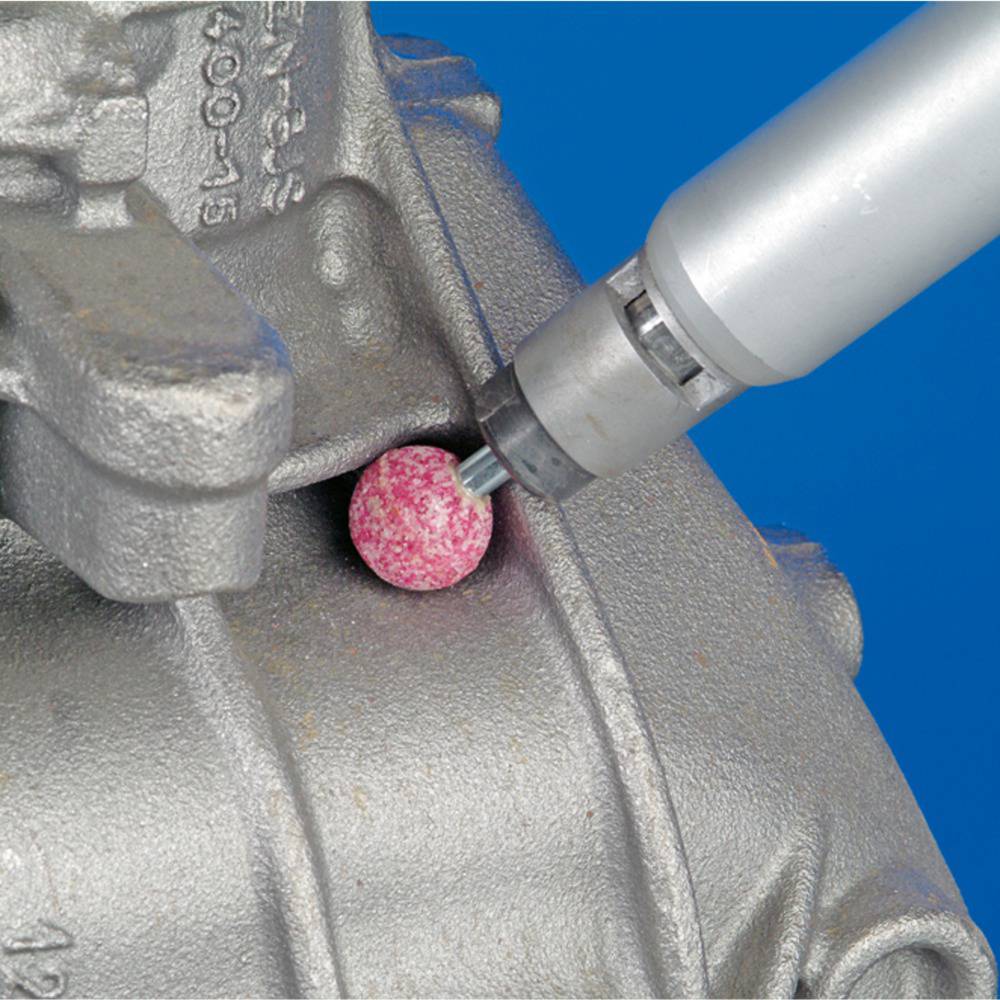 A metallic workpiece is being processed with a rotating grinding attachment to smooth the surface.