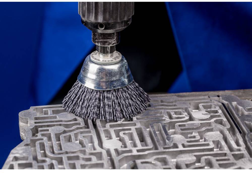 'Industrial brush cleans complex metal surface structure.'