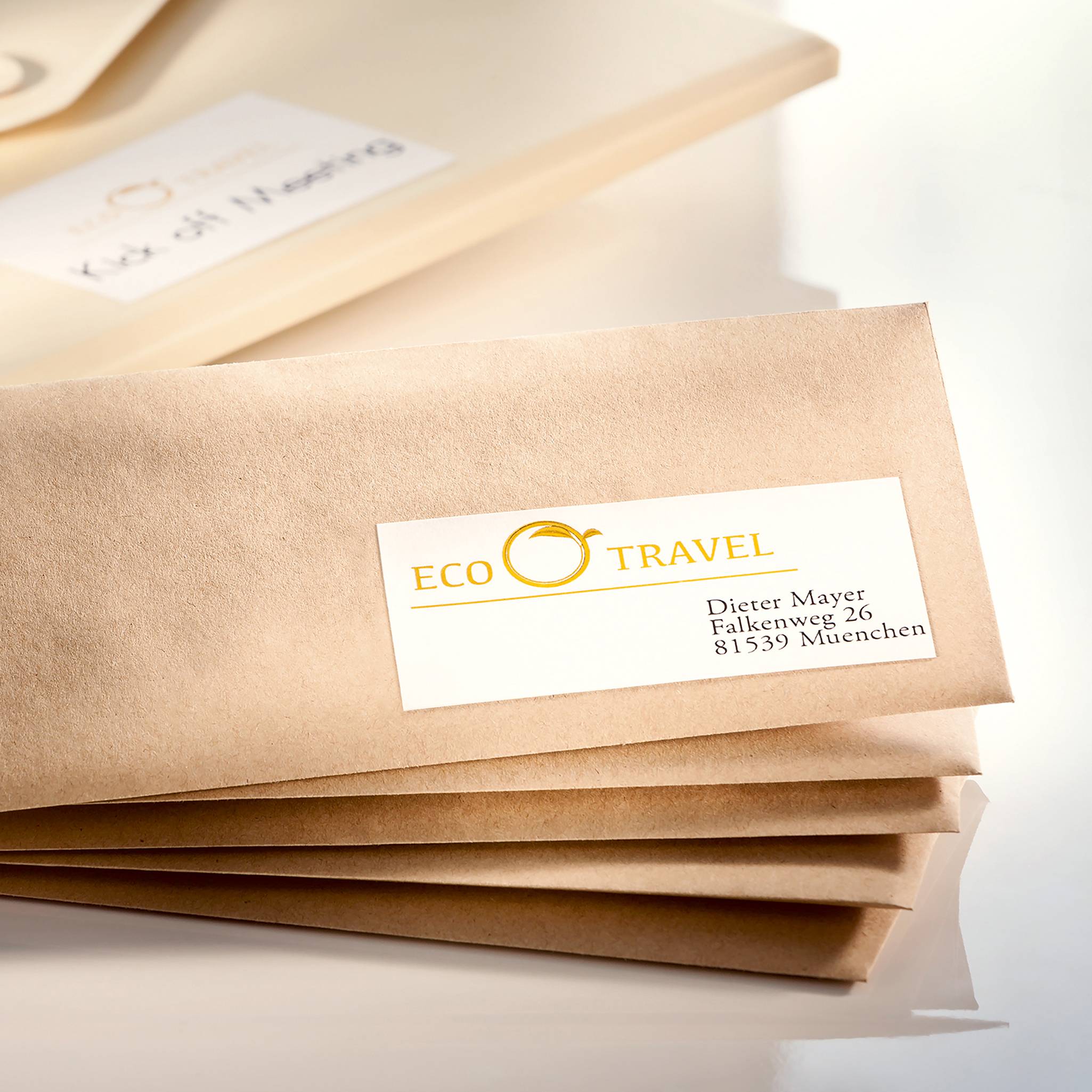 A brown folder with a white label from the company 'ECO TRAVEL', underneath which is the address: 'Dietmar Mayer, 23 Kaiser Street, 81539 Munich'.