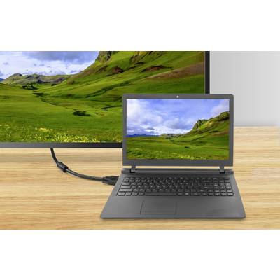 A laptop connected to a larger monitor via an HDMI cable, both displaying an image of green hills and clouds.