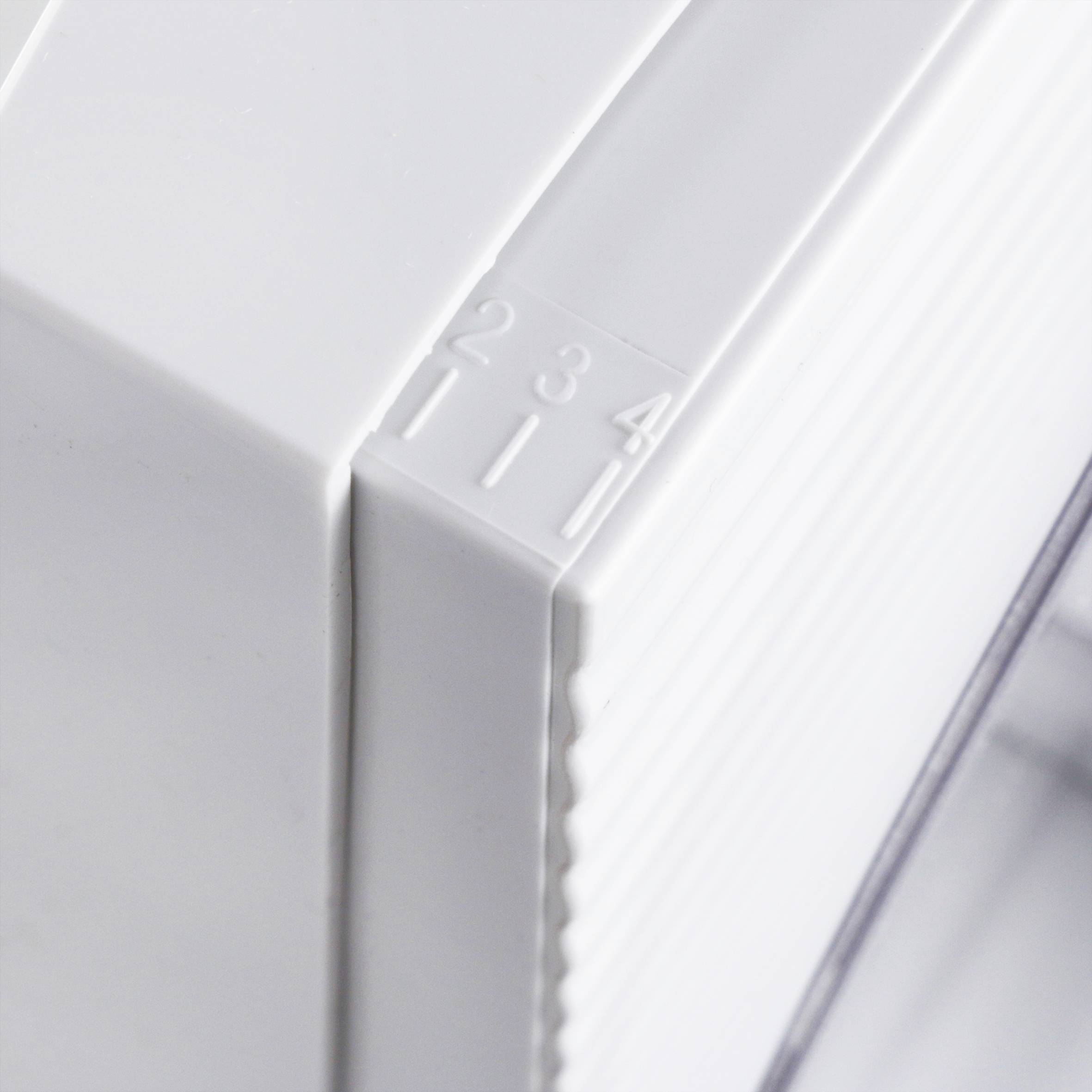 Close-up of a whitish thermostat with a scale from one to four for temperature adjustment.