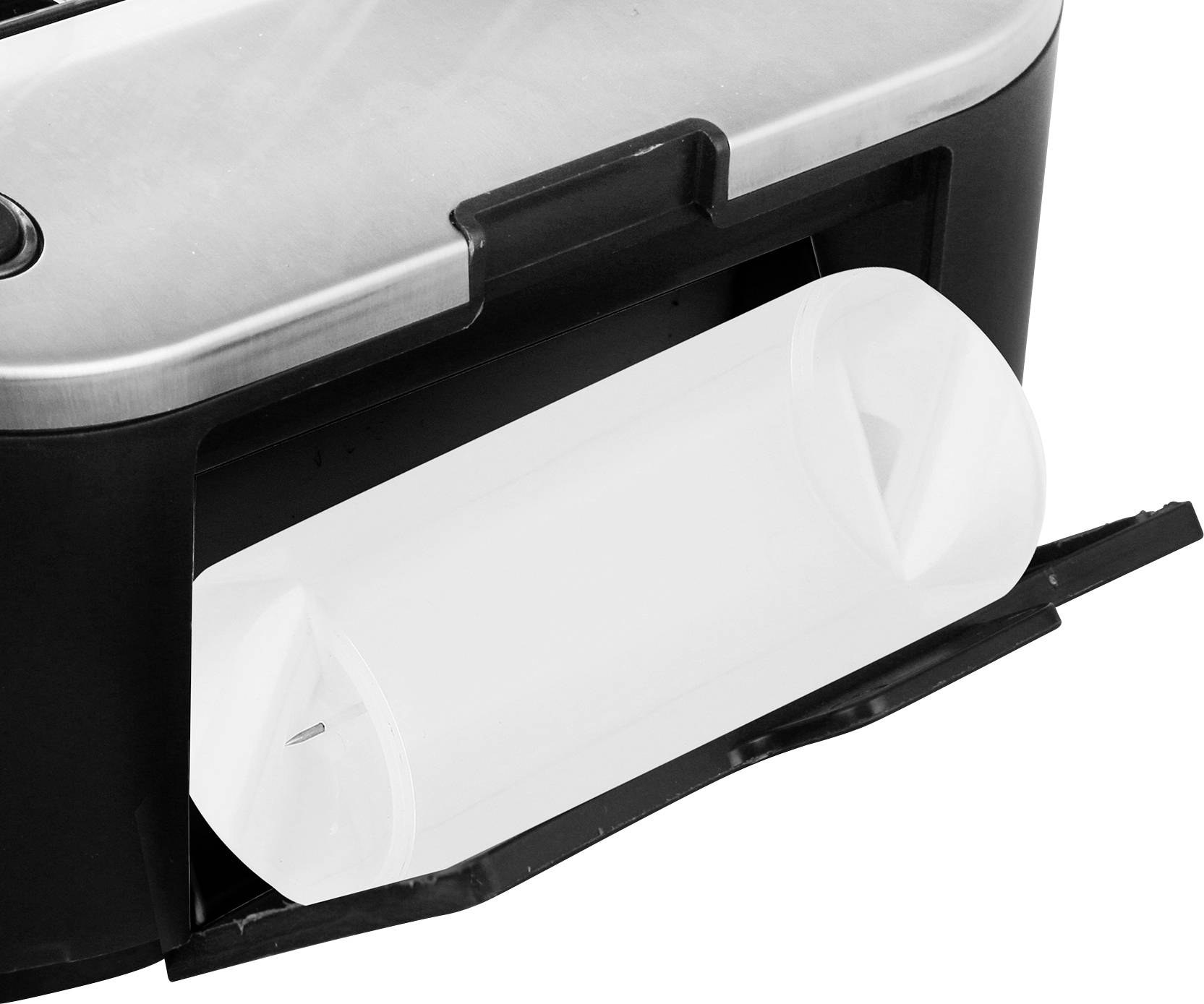 An open cardboard box in a packaging process, possibly the paper feed tray of a printer, with a visible, empty paper roll.