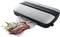 A vacuum sealer seals a bag containing fresh meat and herbs to extend shelf life and keep food fresh.