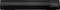 Black soundbar with LED display and control buttons on the right. Display shows 'b6 UE'. Brand name visible in the bottom right.