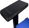 Armrest of a chair made of black plastic with a carbon detail, partially visible against a blue fabric background.