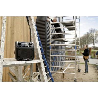 'Outdoor workplace with scaffolding: two men on the scaffold installing panels; a radio sits on the ladder.'