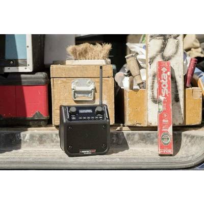 A portable radio sits open on the load bed of a vehicle. Surrounded by tools and a spirit level.