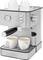 Silver espresso machine with two cups of coffee underneath and two empty cups on top. Includes buttons and a pressure gauge.
